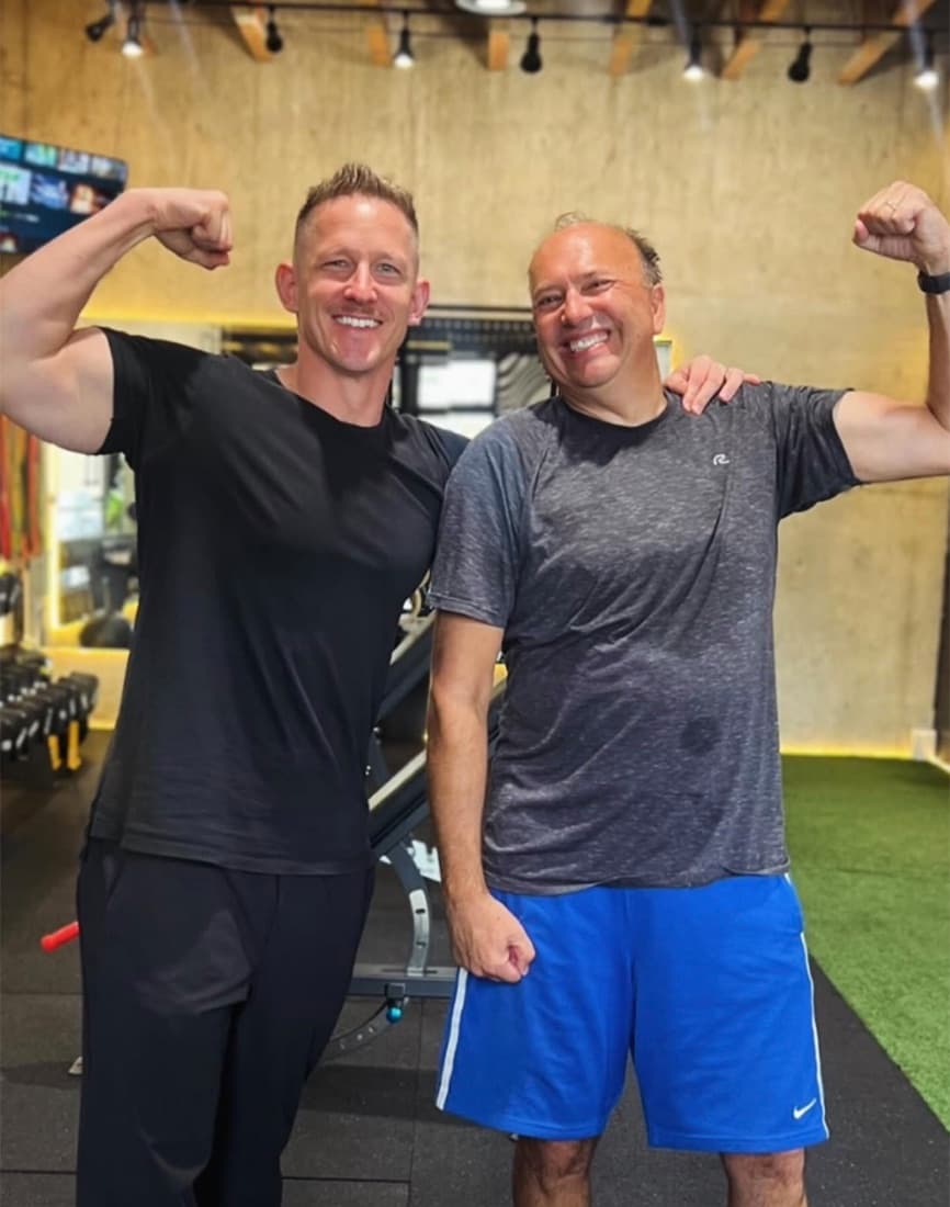 A Leaner Fitness coach and member celebrating progress together